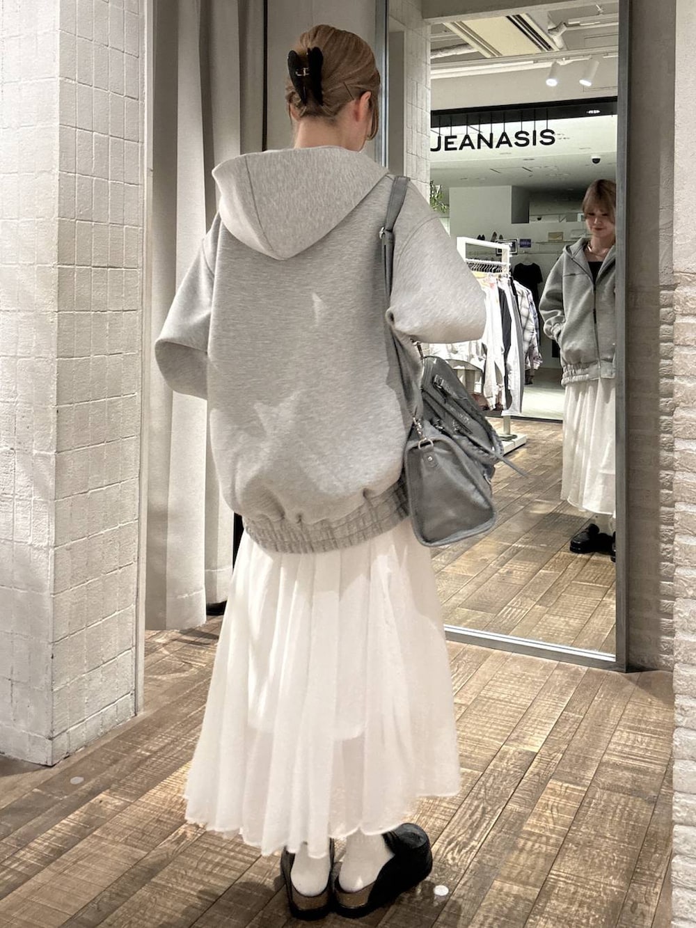 グレー系のブルゾン、ブラック系のローファー、ブルー系のボストンバッグを着用したレディースの春コーディネートの3枚目の写真