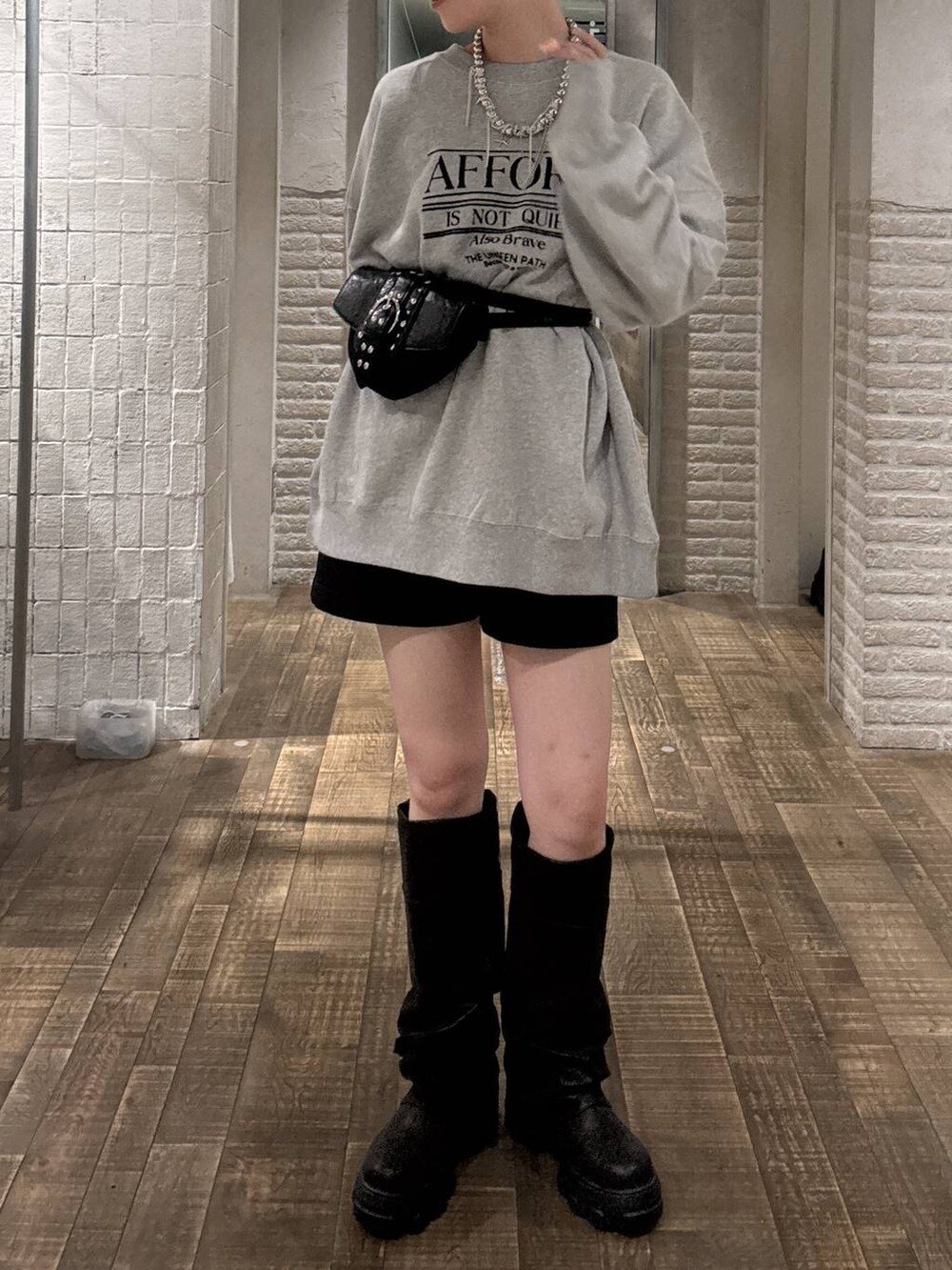 ブラック系のショルダーバッグ、ブラック系のブーツ、グレー系のスウェットを着用したレディースの秋コーディネートの4枚目の写真