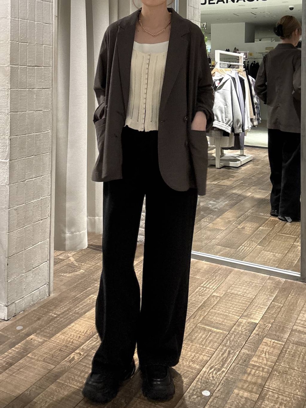 ブラック系のローファー、ブラック系のデニムパンツ、ブラウン系のテーラードジャケットを着用したレディースの春コーディネートの4枚目の写真