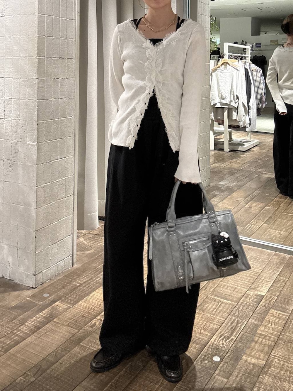 ブラウン系のローファー、ブルー系のボストンバッグ、ブラック系のスウェットパンツを着用したレディースの春コーディネートの4枚目の写真