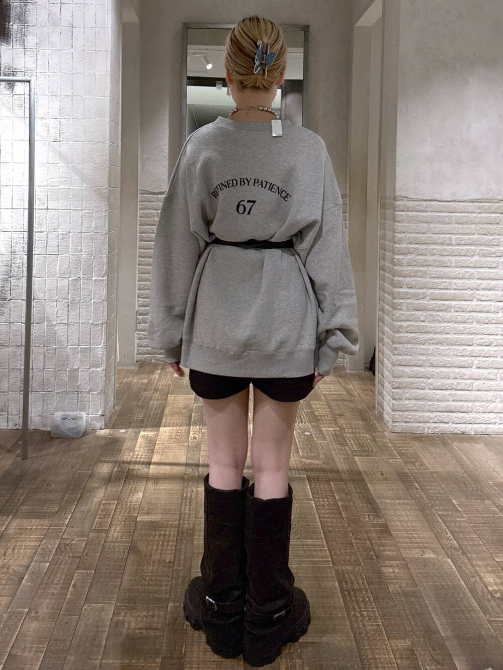 ブラック系のショルダーバッグ、ブラック系のブーツ、グレー系のスウェットを着用したレディースの秋コーディネートの3枚目の写真