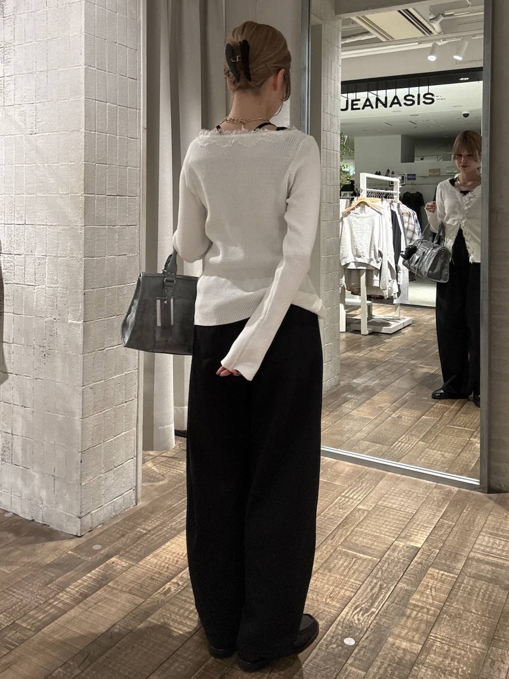 ブラウン系のローファー、ブルー系のボストンバッグ、ブラック系のスウェットパンツを着用したレディースの春コーディネートの3枚目の写真