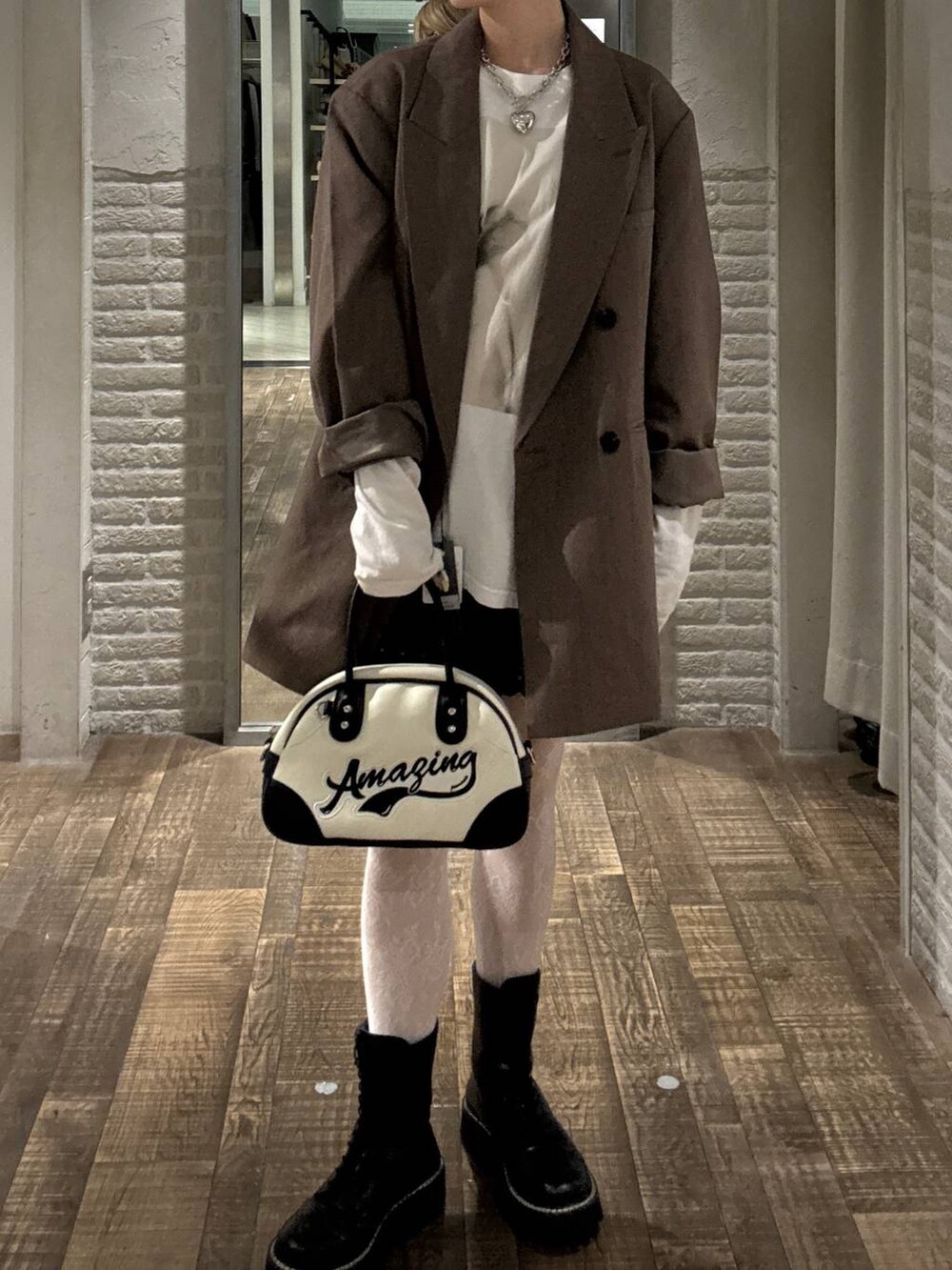 グレー系のテーラードジャケット、ホワイト系のショルダーバッグ、ホワイト系のTシャツ/カットソーを着用したレディースの秋コーディネートの4枚目の写真