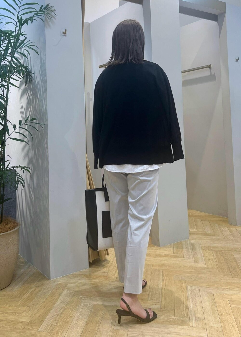 ブラック系のトートバッグ、ブラック系のサンダル、グレー系のその他パンツを着用したレディースの春コーディネートの2枚目の写真