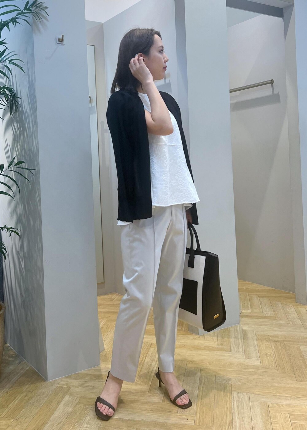 ブラック系のトートバッグ、ブラック系のサンダル、グレー系のその他パンツを着用したレディースの春コーディネートの3枚目の写真