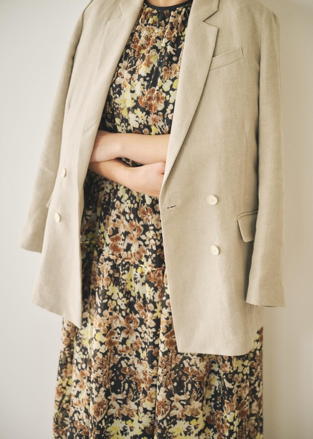 ベージュ系のテーラードジャケット、ブラック系のサンダル、ブラウン系のワンピースを着用したレディースの春コーディネートの4枚目の写真