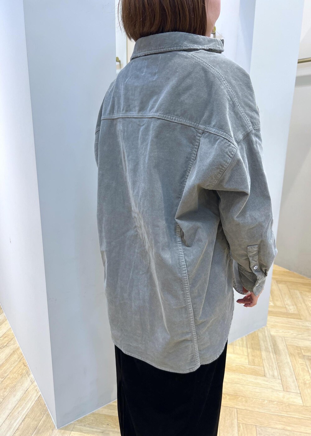 ブラック系のスカート、ブラック系のパンプス、ベージュ系のタンクトップを着用したレディースの秋コーディネートの6枚目の写真