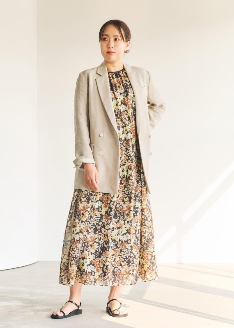 ベージュ系のテーラードジャケット、ブラック系のサンダル、ブラウン系のワンピースを着用したレディースの春コーディネートの2枚目の写真