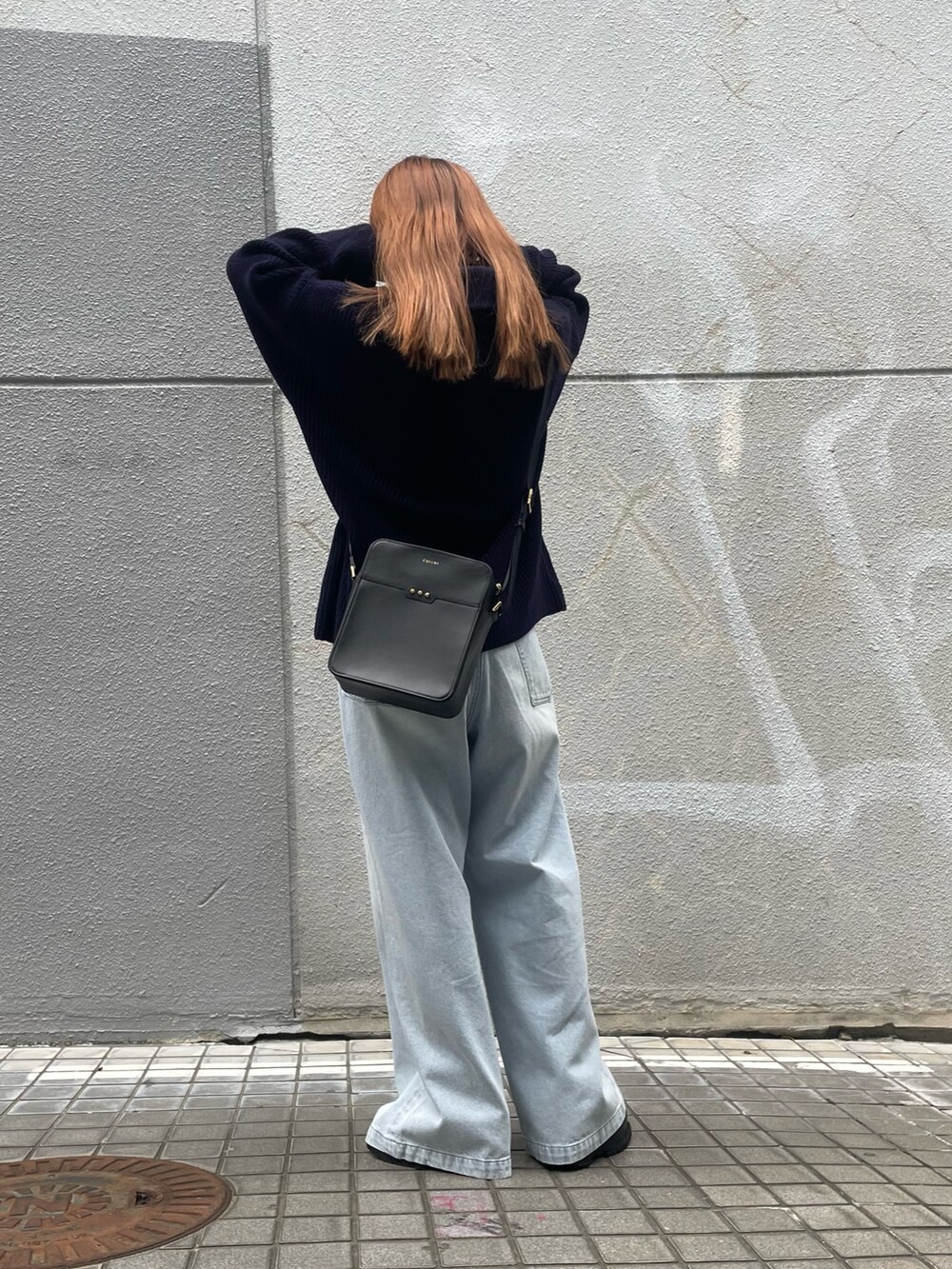 ブルー系のデニムパンツ、ブラック系のその他アウターを着用したレディースの冬コーディネートの2枚目の写真