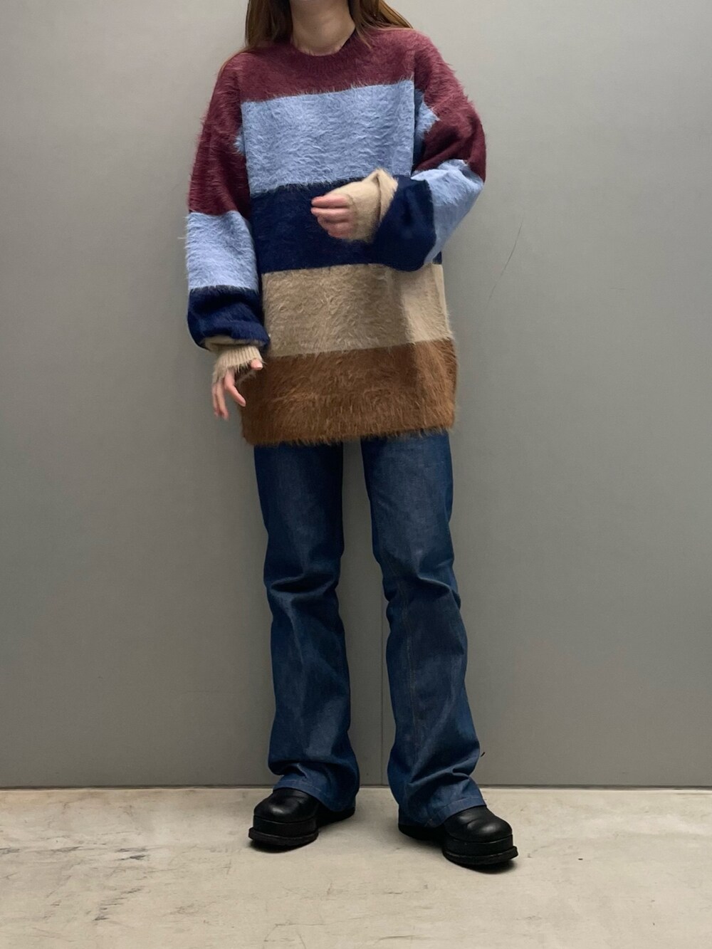 レッド系のニット/セーターを着用したレディースの秋コーディネートの2枚目の写真