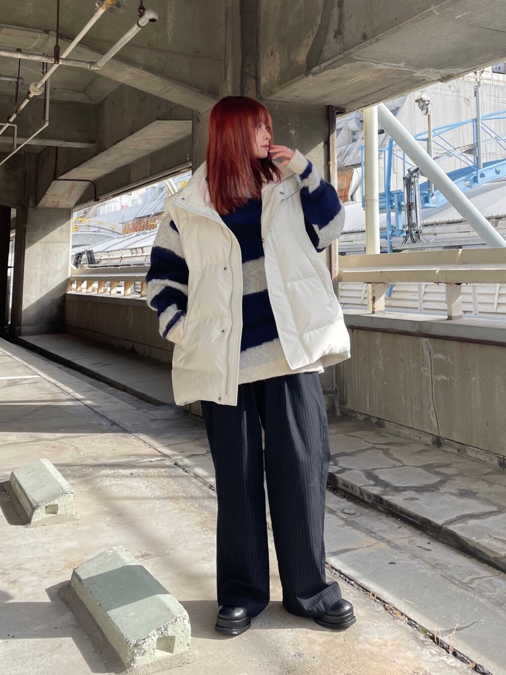 パープル系のニット/セーター、ホワイト系のダウンベストを着用したレディースの冬コーディネートの2枚目の写真