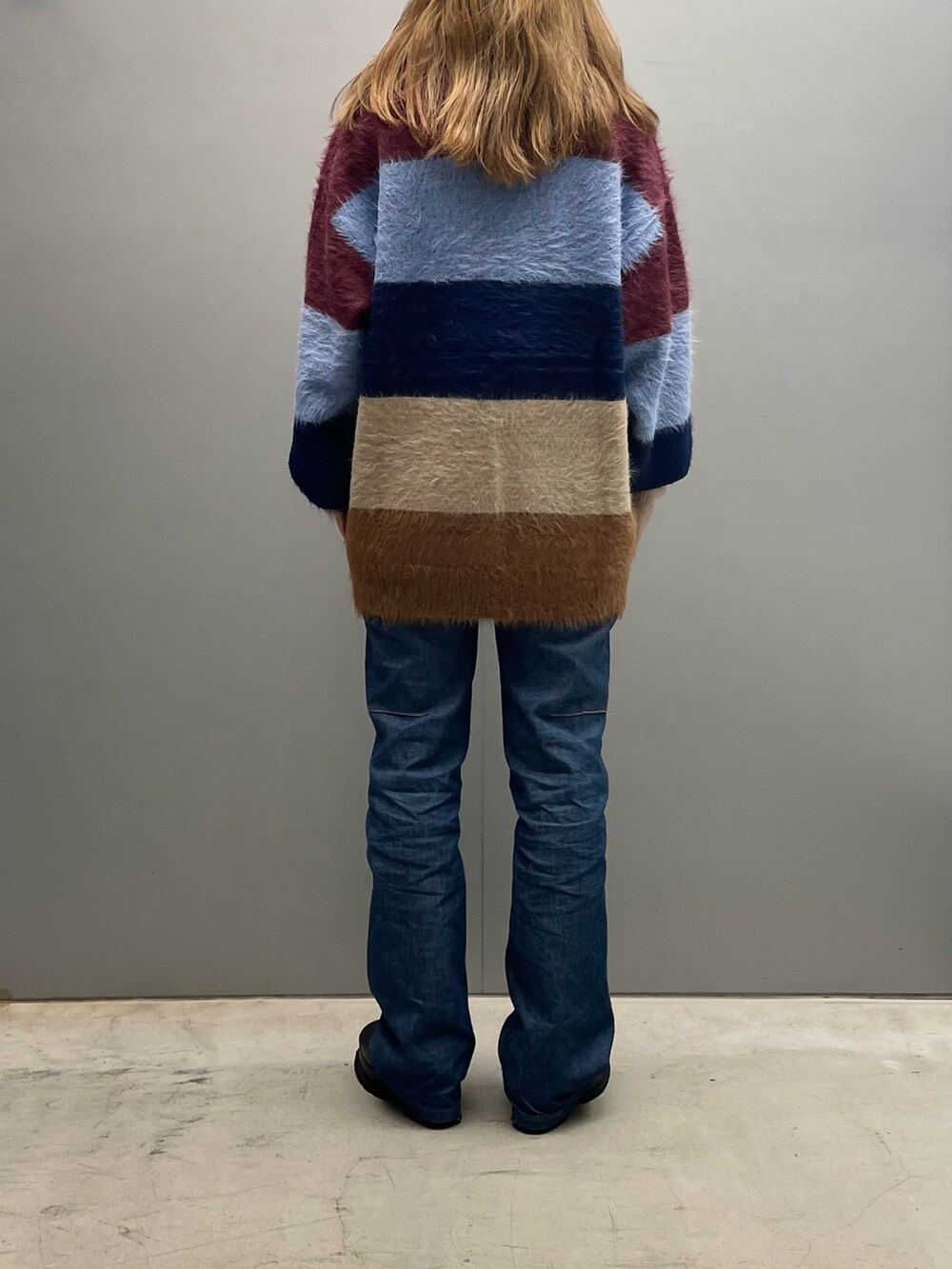 レッド系のニット/セーターを着用したレディースの秋コーディネートの3枚目の写真