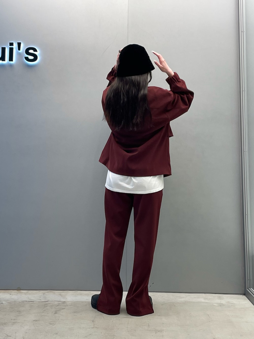 レッド系のブルゾン、ホワイト系のブーツ、レッド系のその他パンツを着用したレディースの秋コーディネートの2枚目の写真