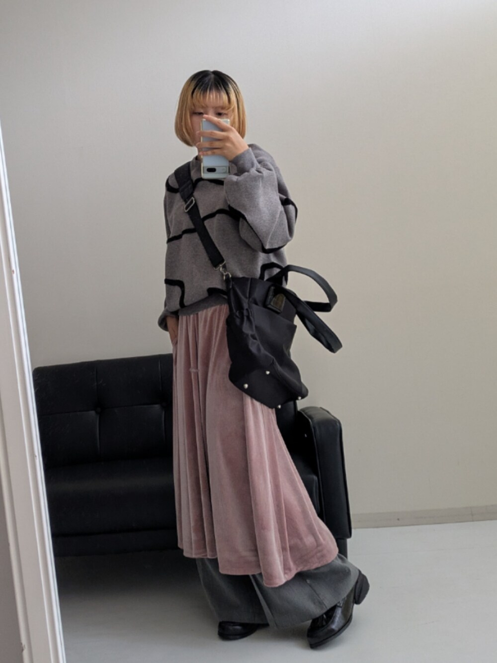 ブラック系のトートバッグ、ピンク系のワンピース、グレー系のスラックスを着用したレディースの秋コーディネートの3枚目の写真