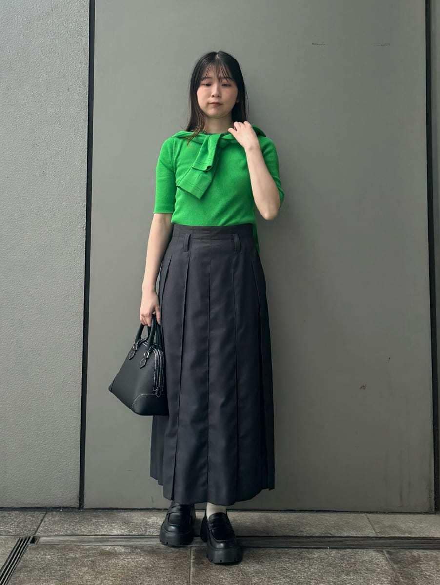 グレー系のスカート、グリーン系のカーディガン/ボレロ、グリーン系のニット/セーターを着用したレディースの春コーディネートの2枚目の写真