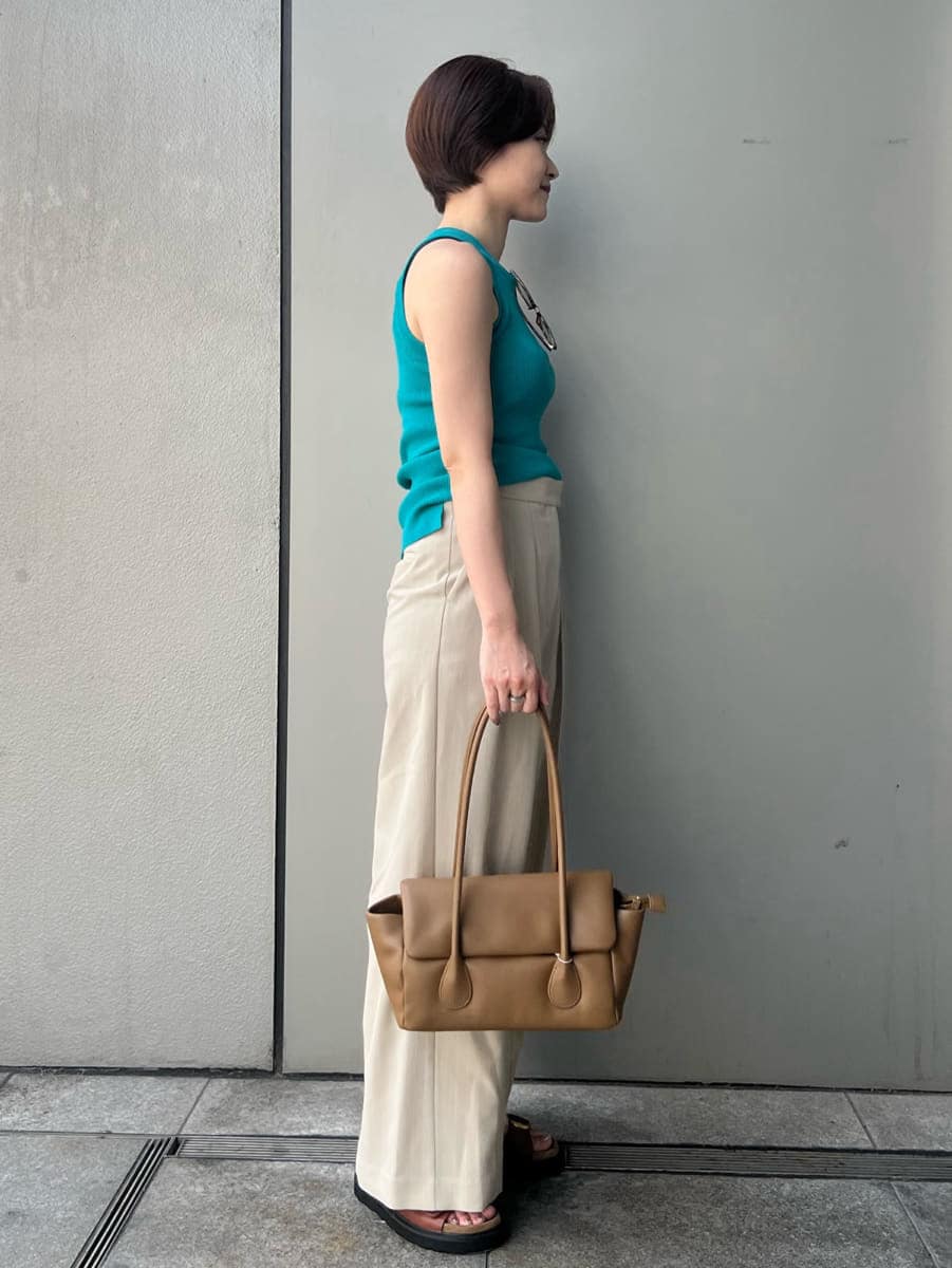 ブルー系のニット/セーター、ベージュ系のその他パンツ、ブラウン系のショルダーバッグを着用したレディースの夏コーディネートの3枚目の写真