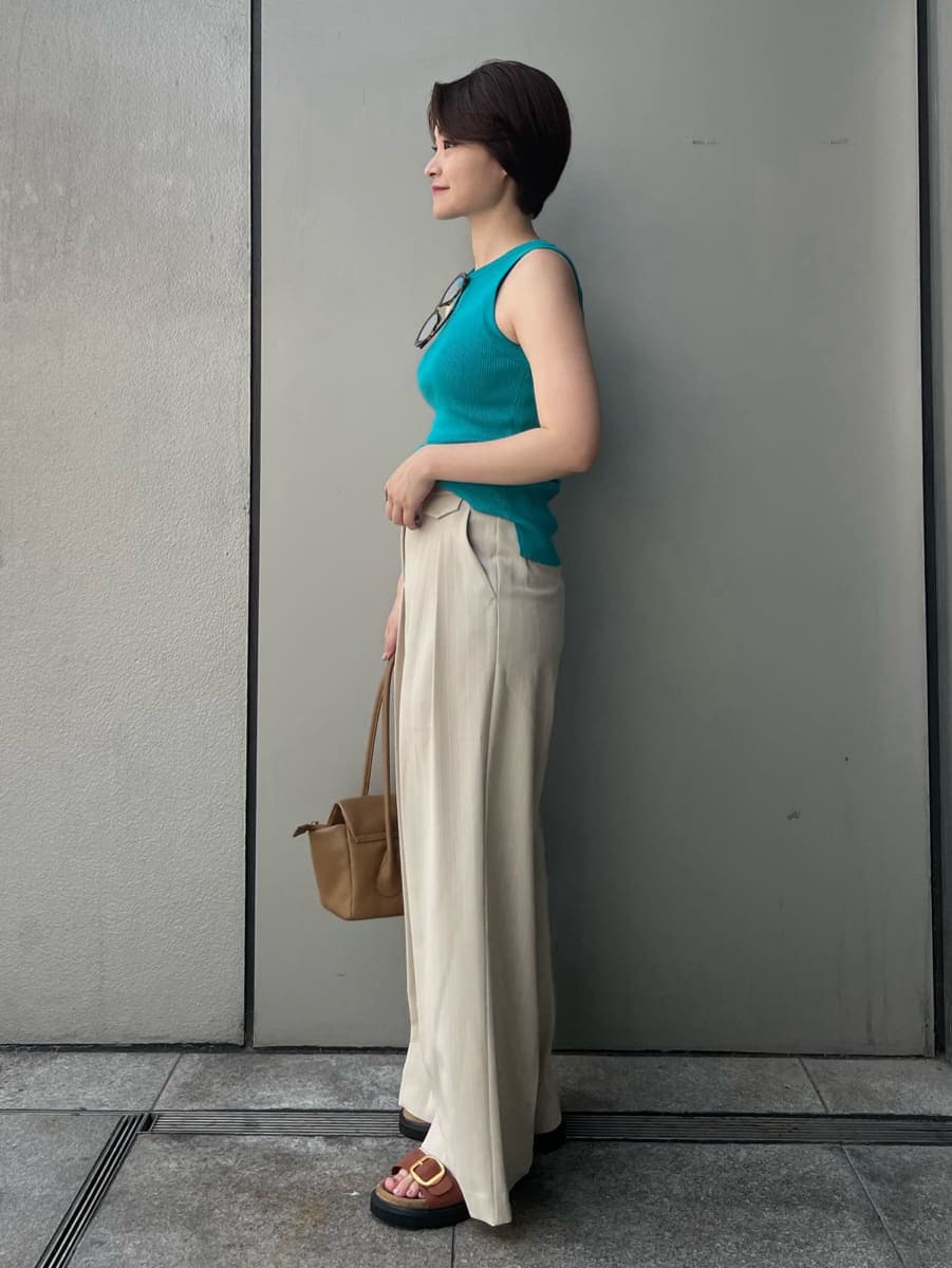 ブルー系のニット/セーター、ベージュ系のその他パンツ、ブラウン系のショルダーバッグを着用したレディースの夏コーディネートの2枚目の写真