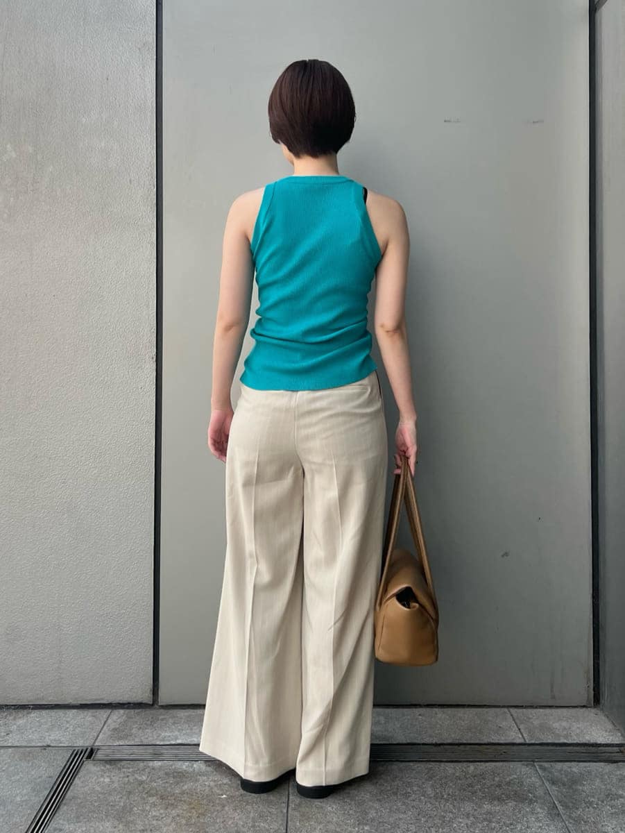 ブルー系のニット/セーター、ベージュ系のその他パンツ、ブラウン系のショルダーバッグを着用したレディースの夏コーディネートの4枚目の写真