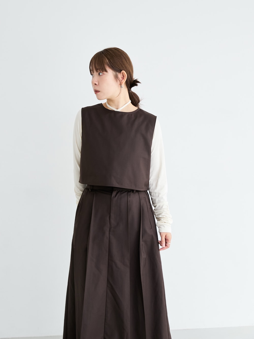 ブラウン系のワンピース/ドレス、ブラウン系のワンピース、ホワイト系のTシャツ/カットソーを着用したレディースの秋コーディネートの3枚目の写真