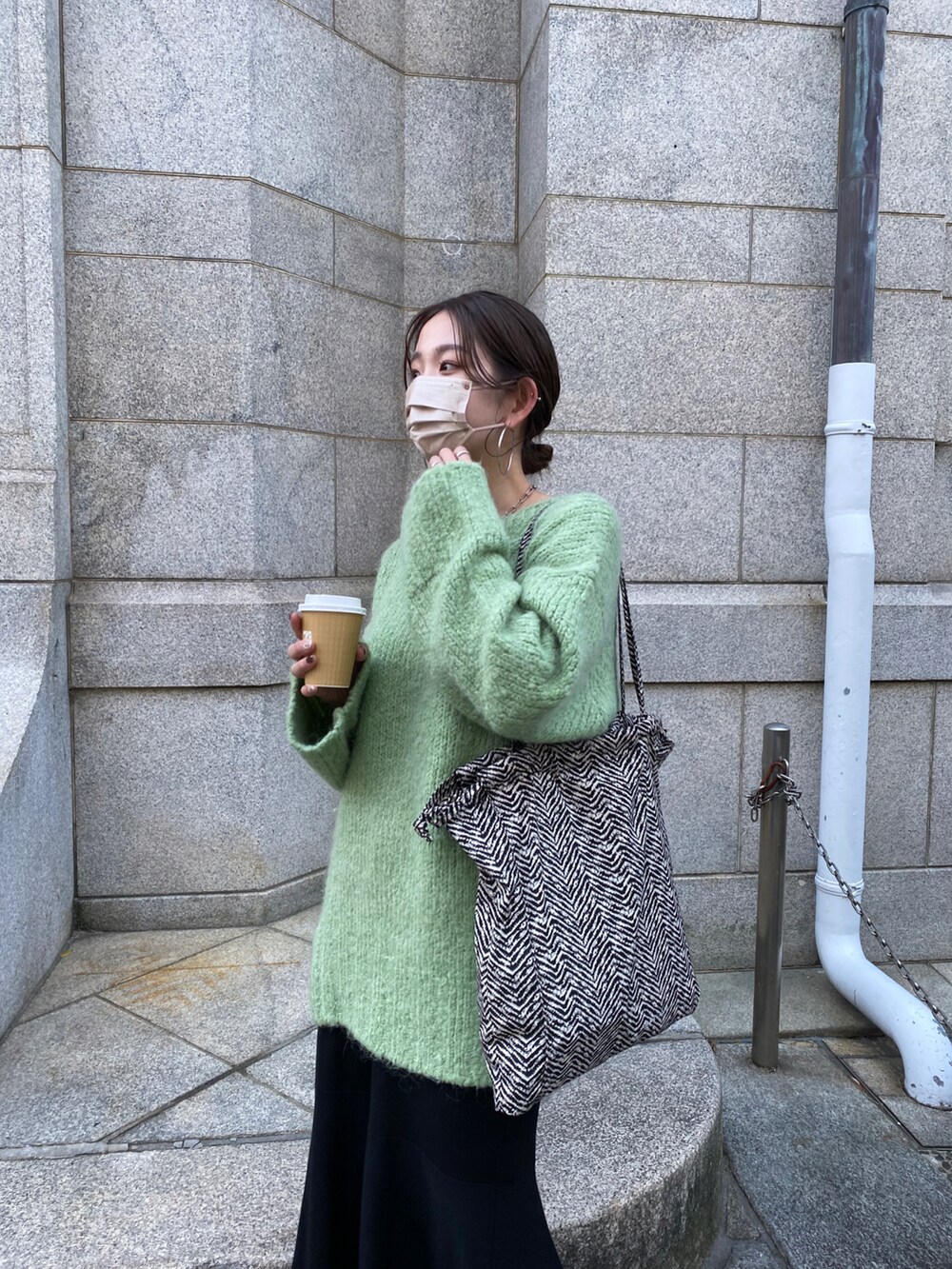 グリーン系のニット/セーターを着用したレディースの冬コーディネートの2枚目の写真