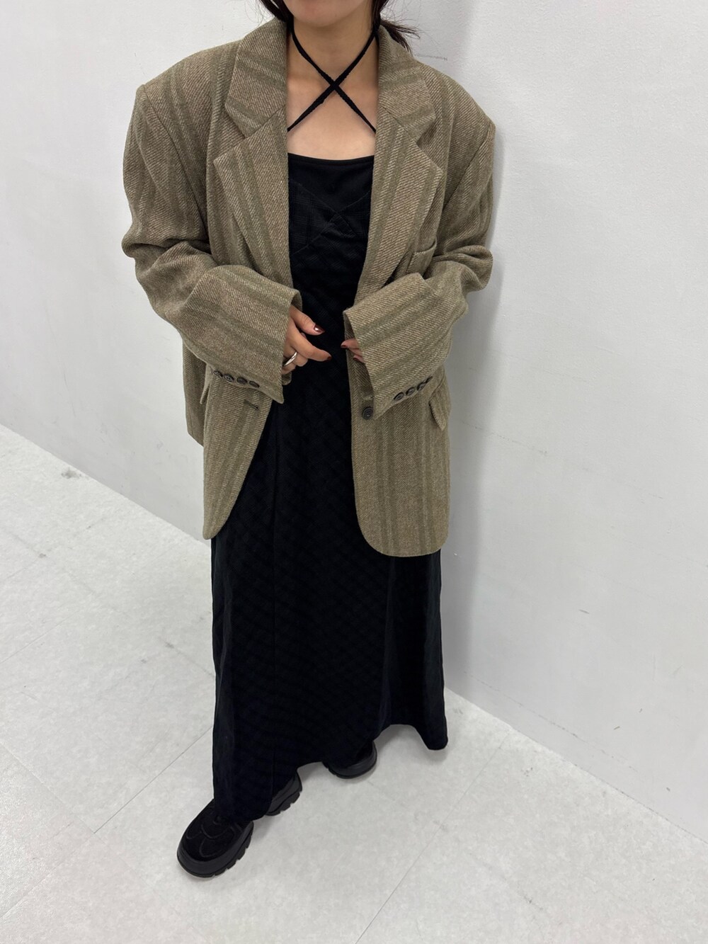 ブラック系のワンピース、ブラック系のスニーカーを着用したレディースの秋コーディネートの2枚目の写真