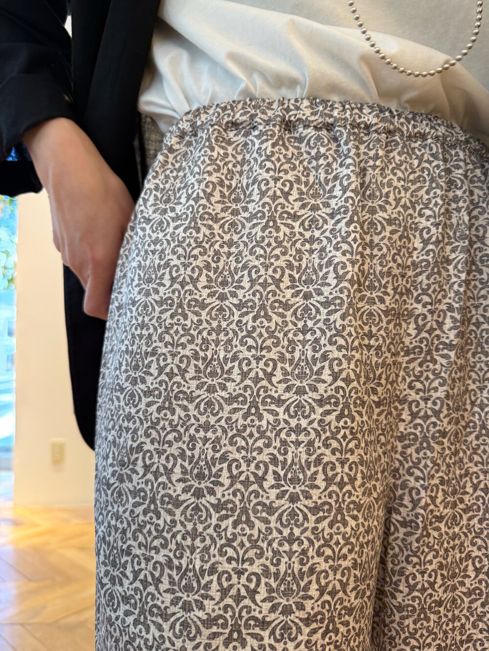 ブラック系のテーラードジャケット、ブラック系のその他パンツ、ブルー系のトートバッグを着用したレディースの夏コーディネートの4枚目の写真