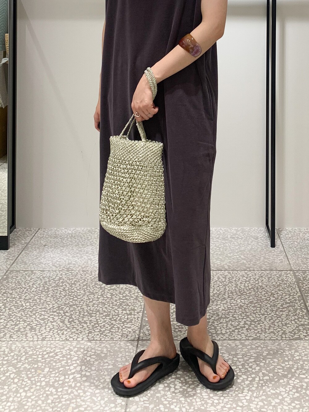 シルバー系のかごバッグ、パープル系のワンピース、シルバー系のネックレスを着用したレディースの夏コーディネートの3枚目の写真