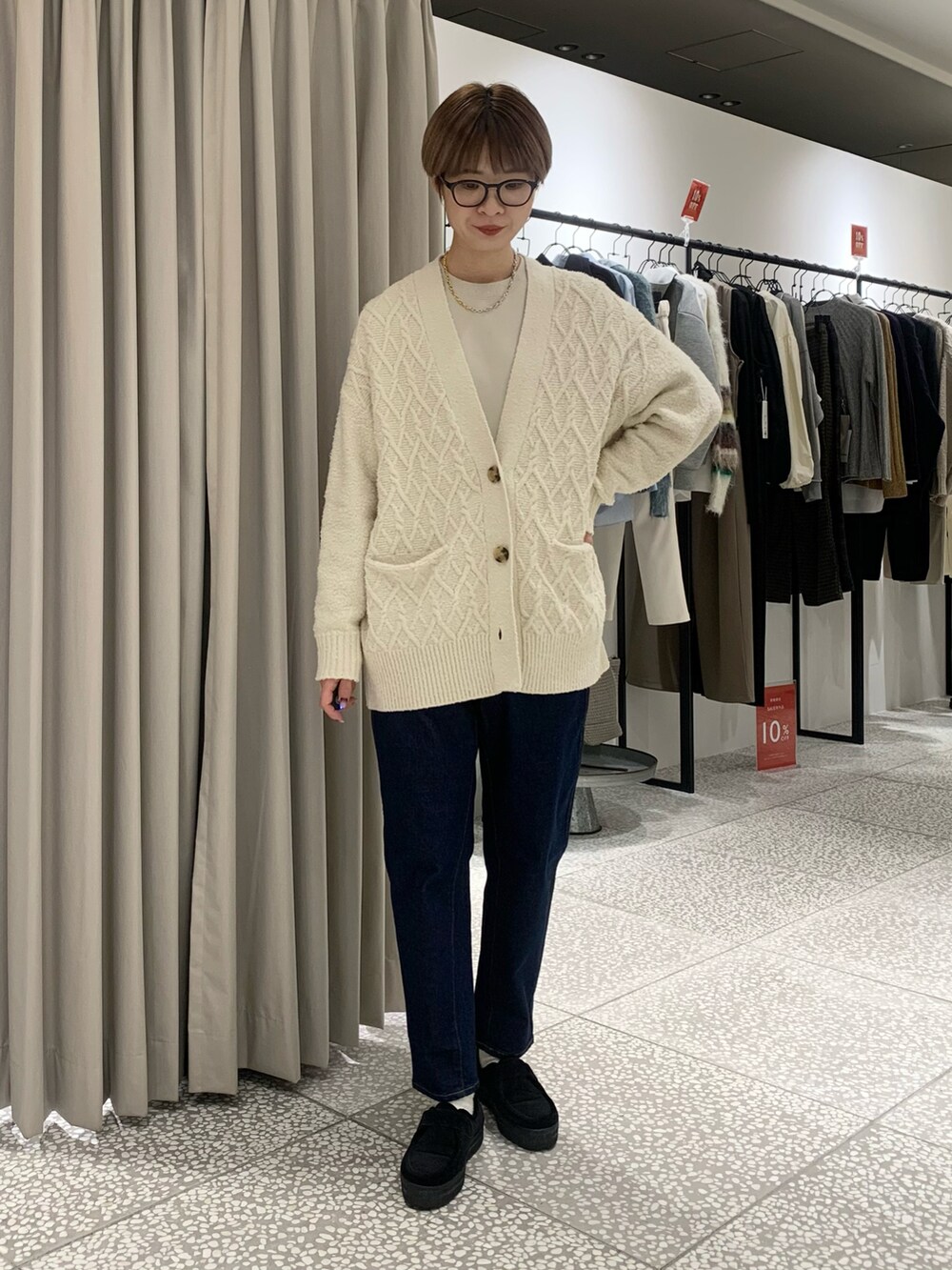 ブラック系のボストンバッグ、ブルー系のデニムパンツ、ベージュ系のスウェットを着用したレディースの冬コーディネートの5枚目の写真