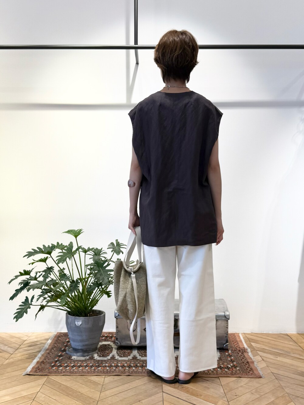 ホワイト系のタンクトップ、グレー系のセットアップ、ベージュ系のショルダーバッグを着用したレディースの夏コーディネートの3枚目の写真