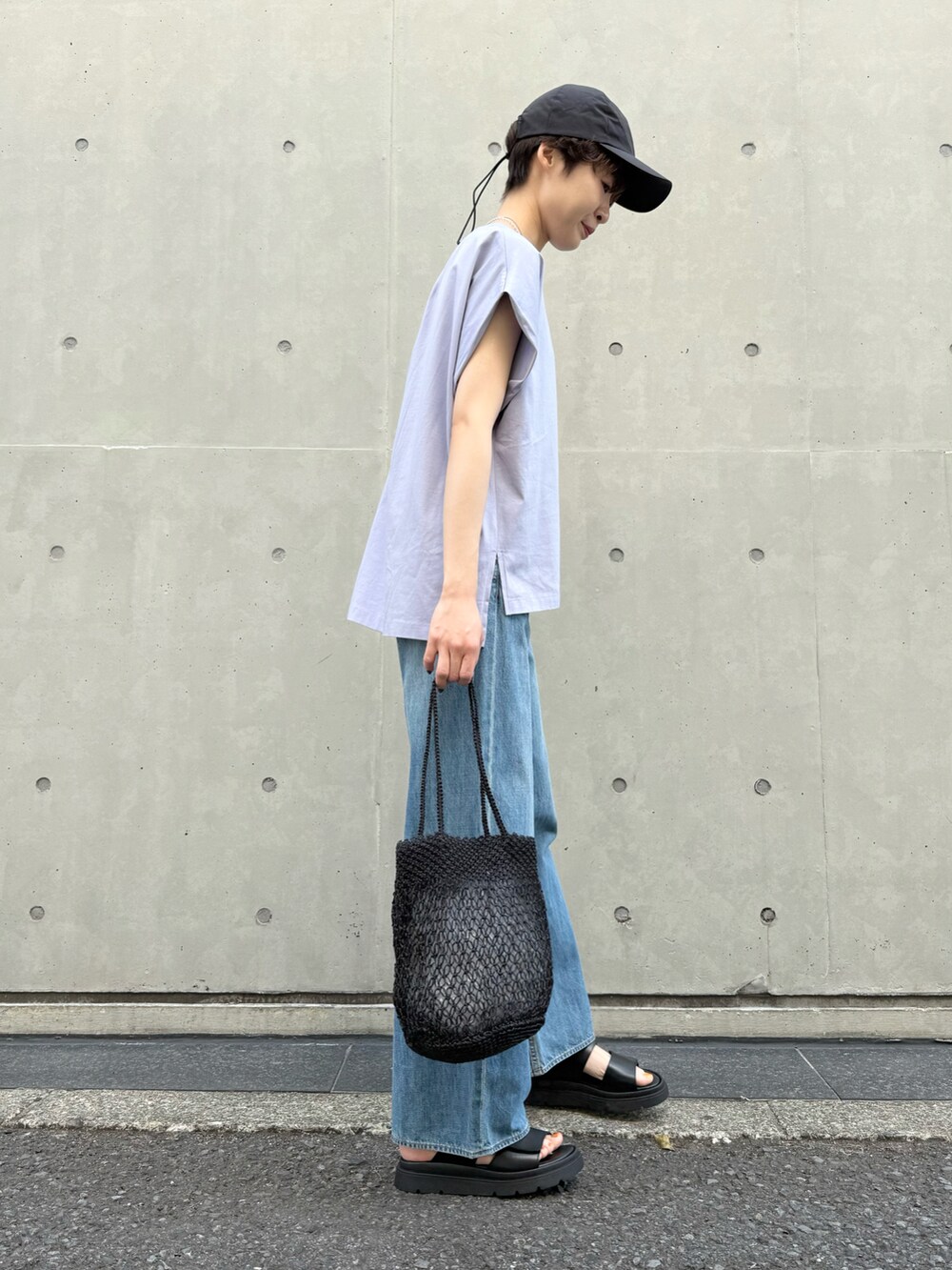 パープル系のTシャツ/カットソー、ブルー系のデニムパンツ、ブラック系のかごバッグを着用したレディースの夏コーディネートの4枚目の写真