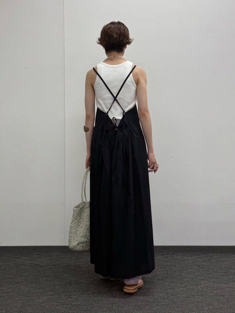 ブラック系のワンピース、ゴールド系のかごバッグ、グリーン系のその他パンツを着用したレディースの夏コーディネートの2枚目の写真