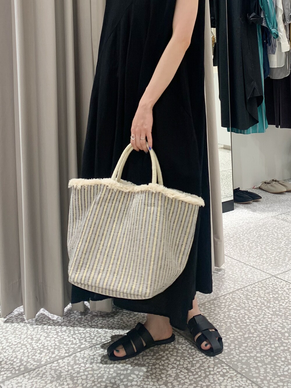 ホワイト系のかごバッグ、ブラック系のワンピース、ブラック系のサンダルを着用したレディースの夏コーディネートの3枚目の写真