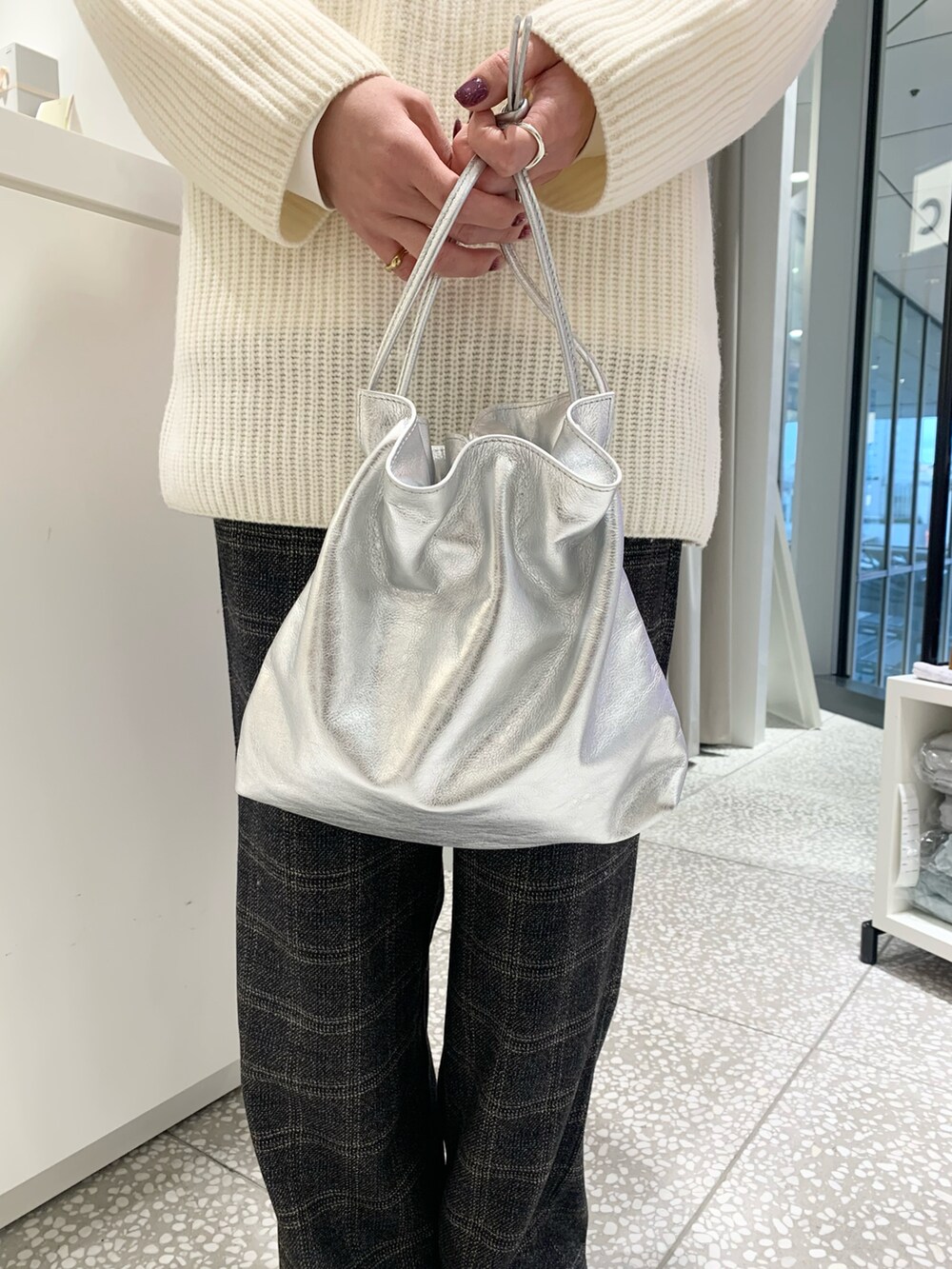 ホワイト系のニット/セーター、ブラック系のその他パンツ、シルバー系のショルダーバッグを着用したレディースの冬コーディネートの5枚目の写真