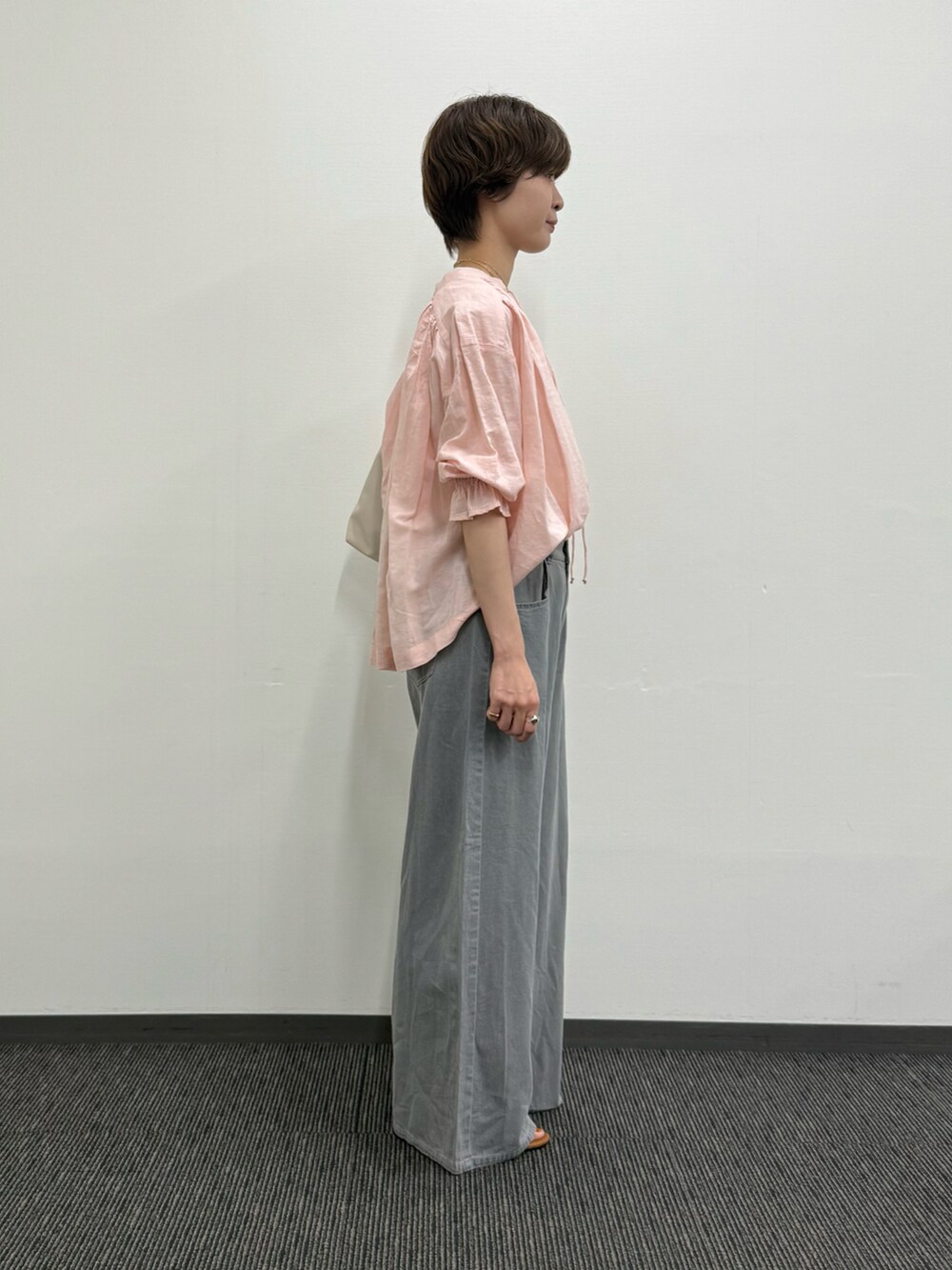 ピンク系のシャツ/ブラウス、グレー系のトートバッグ、グレー系のデニムパンツを着用したレディースの夏コーディネートの4枚目の写真