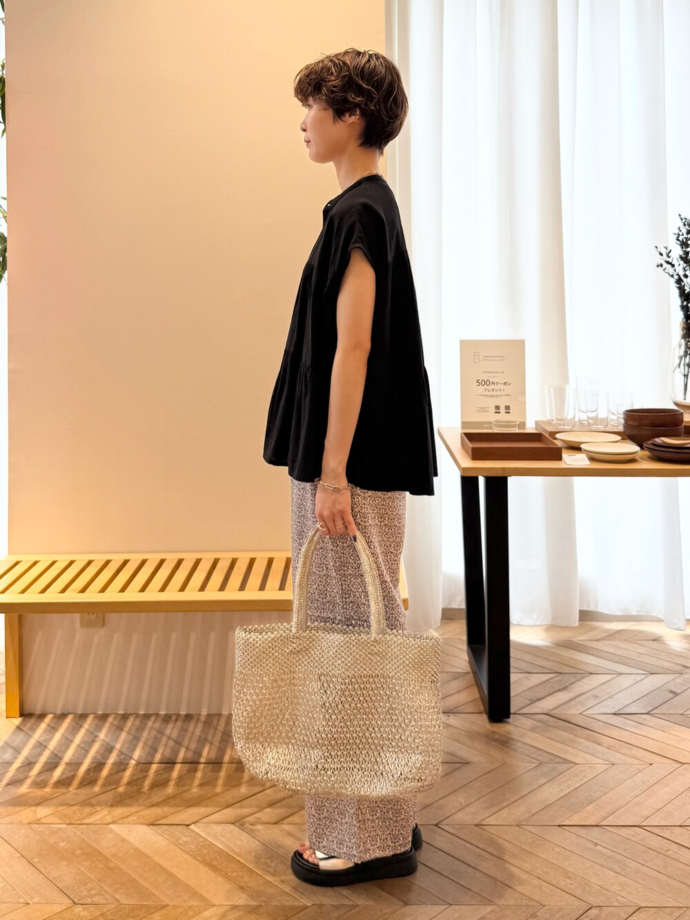 ブラック系のシャツ/ブラウス、ブラック系のその他パンツ、ゴールド系のかごバッグを着用したレディースの夏コーディネートの2枚目の写真