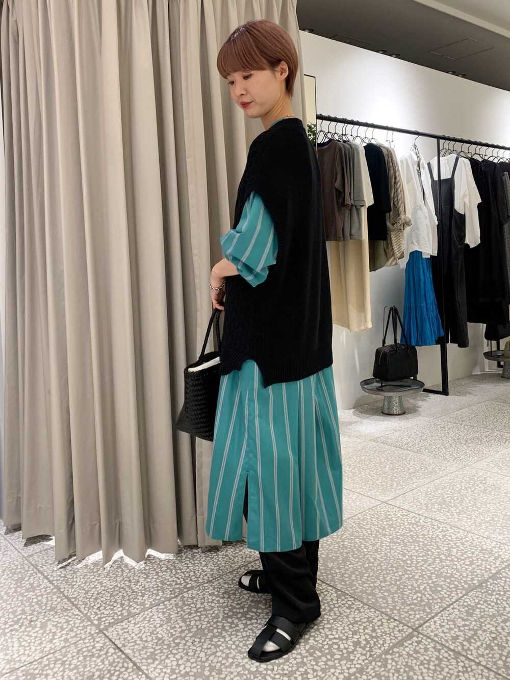 ブラック系のニット/セーター、グリーン系のワンピース、ブラック系のその他パンツを着用したレディースの秋コーディネートの2枚目の写真