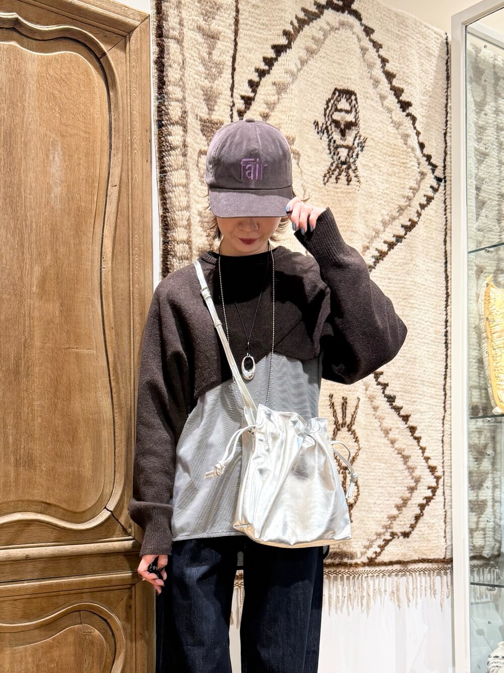 ブラウン系のニット/セーター、ブラック系のTシャツ/カットソー、シルバー系のショルダーバッグを着用したレディースの秋コーディネートの3枚目の写真