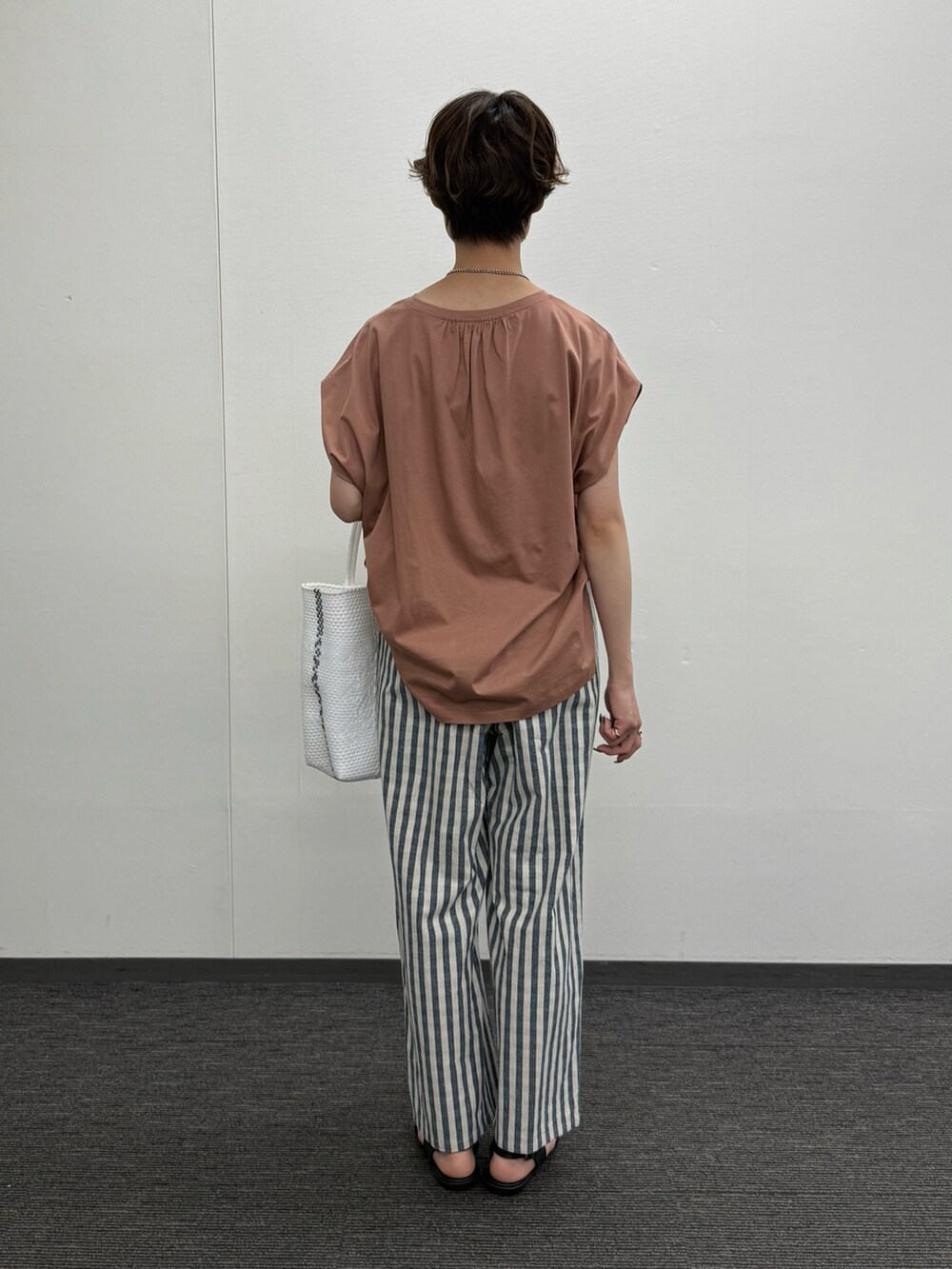 ピンク系のTシャツ/カットソー、ブラック系のその他パンツ、ブラック系のサンダルを着用したレディースの夏コーディネートの3枚目の写真