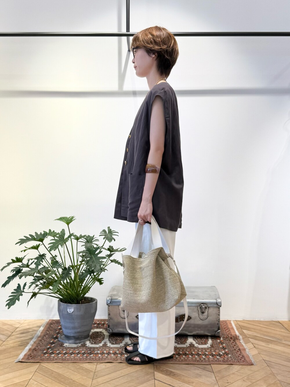 ホワイト系のタンクトップ、グレー系のセットアップ、ベージュ系のショルダーバッグを着用したレディースの夏コーディネートの2枚目の写真