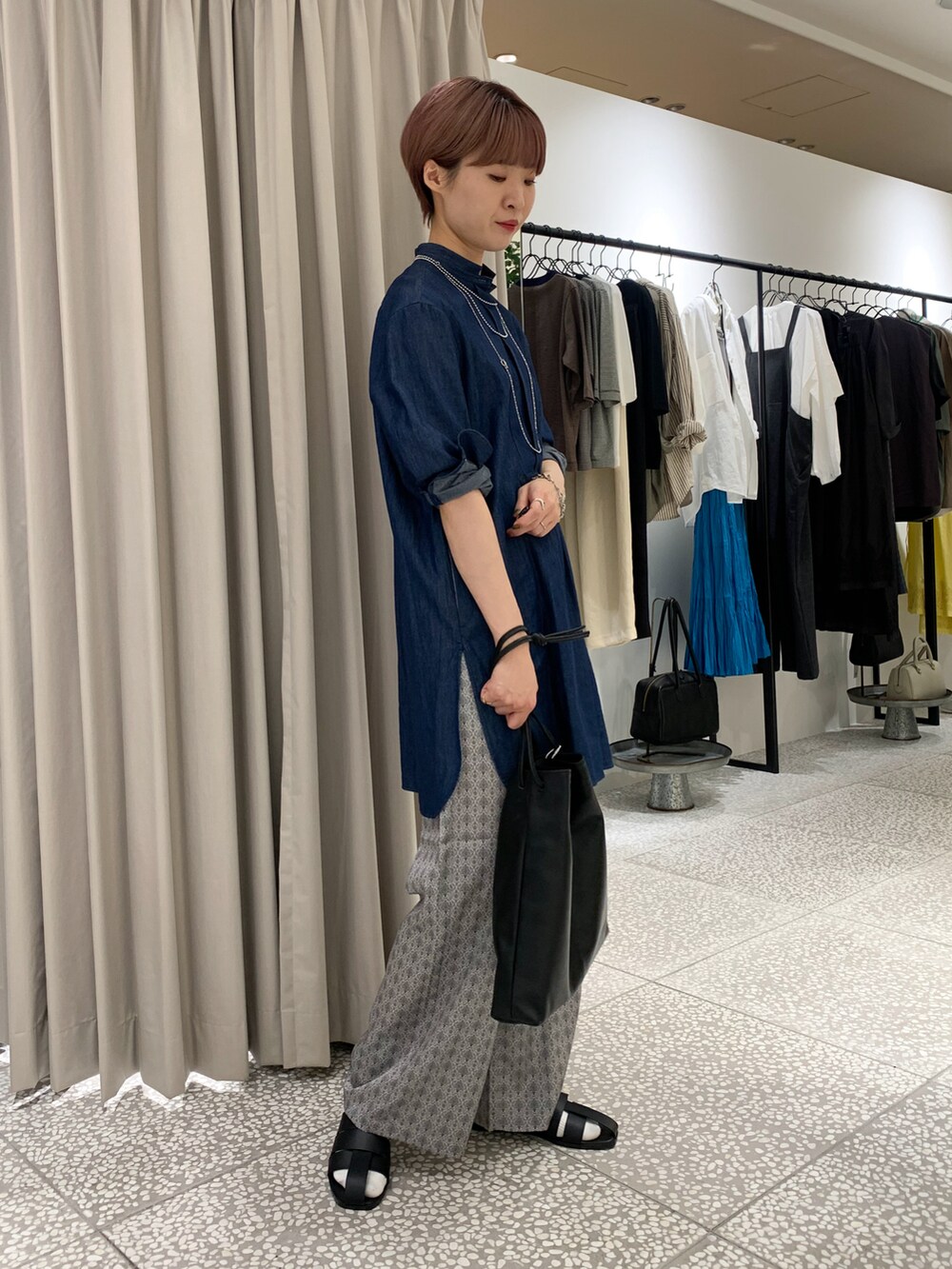 ブルー系のシャツ/ブラウス、ブラック系のトートバッグ、ベージュ系のその他パンツを着用したレディースの秋コーディネートの3枚目の写真