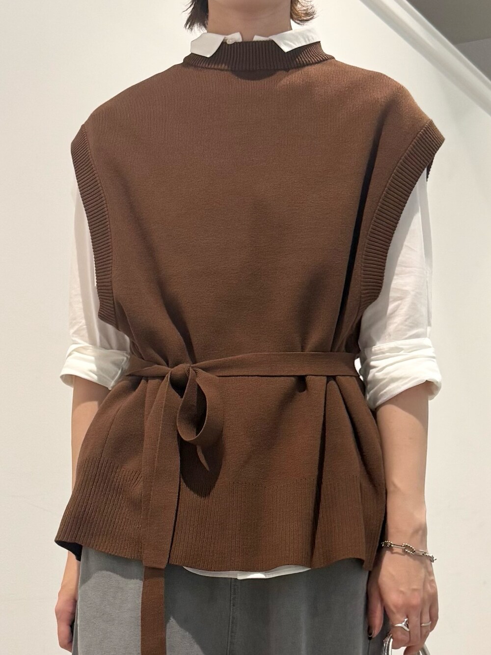 ブラウン系のベスト、ホワイト系のシャツ/ブラウス、グレー系のデニムパンツを着用したレディースの秋コーディネートの5枚目の写真