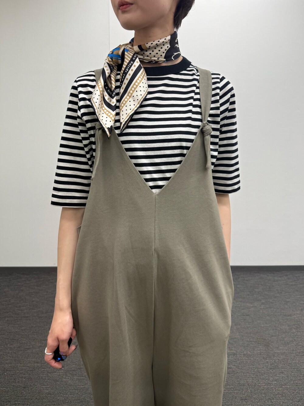 ブラック系のTシャツ/カットソー、ホワイト系のカーディガン/ボレロ、グリーン系のサロペット/オーバーオールを着用したレディースの夏コーディネートの4枚目の写真