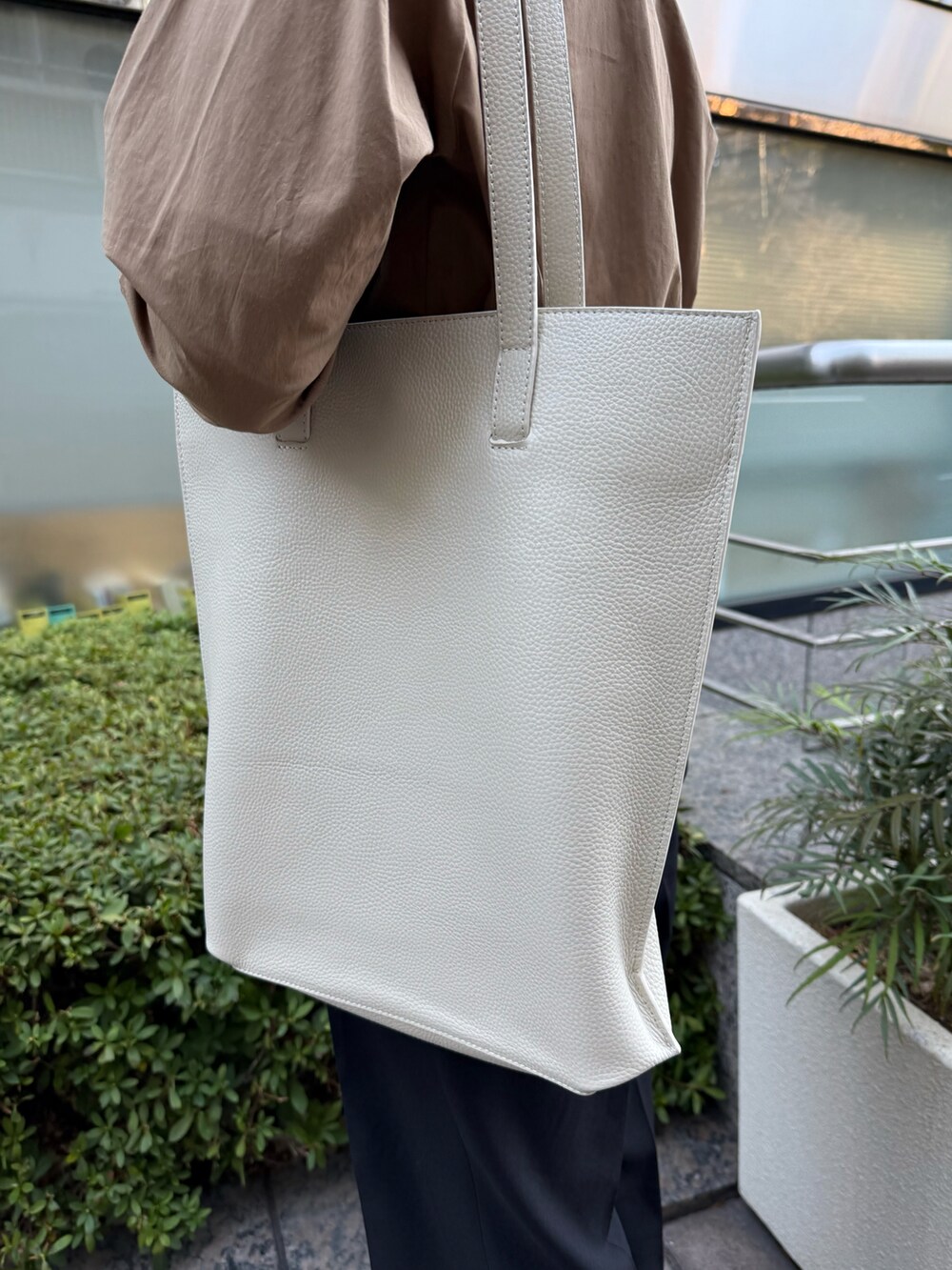 ブラウン系のシャツ/ブラウス、ホワイト系のトートバッグを着用したレディースの春コーディネートの5枚目の写真