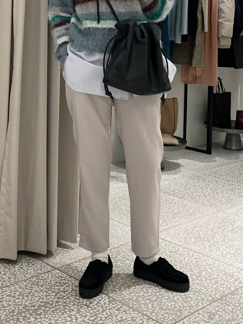 ブルー系のニット/セーター、ブラック系のショルダーバッグ、ブルー系のシャツ/ブラウスを着用したレディースの冬コーディネートの4枚目の写真