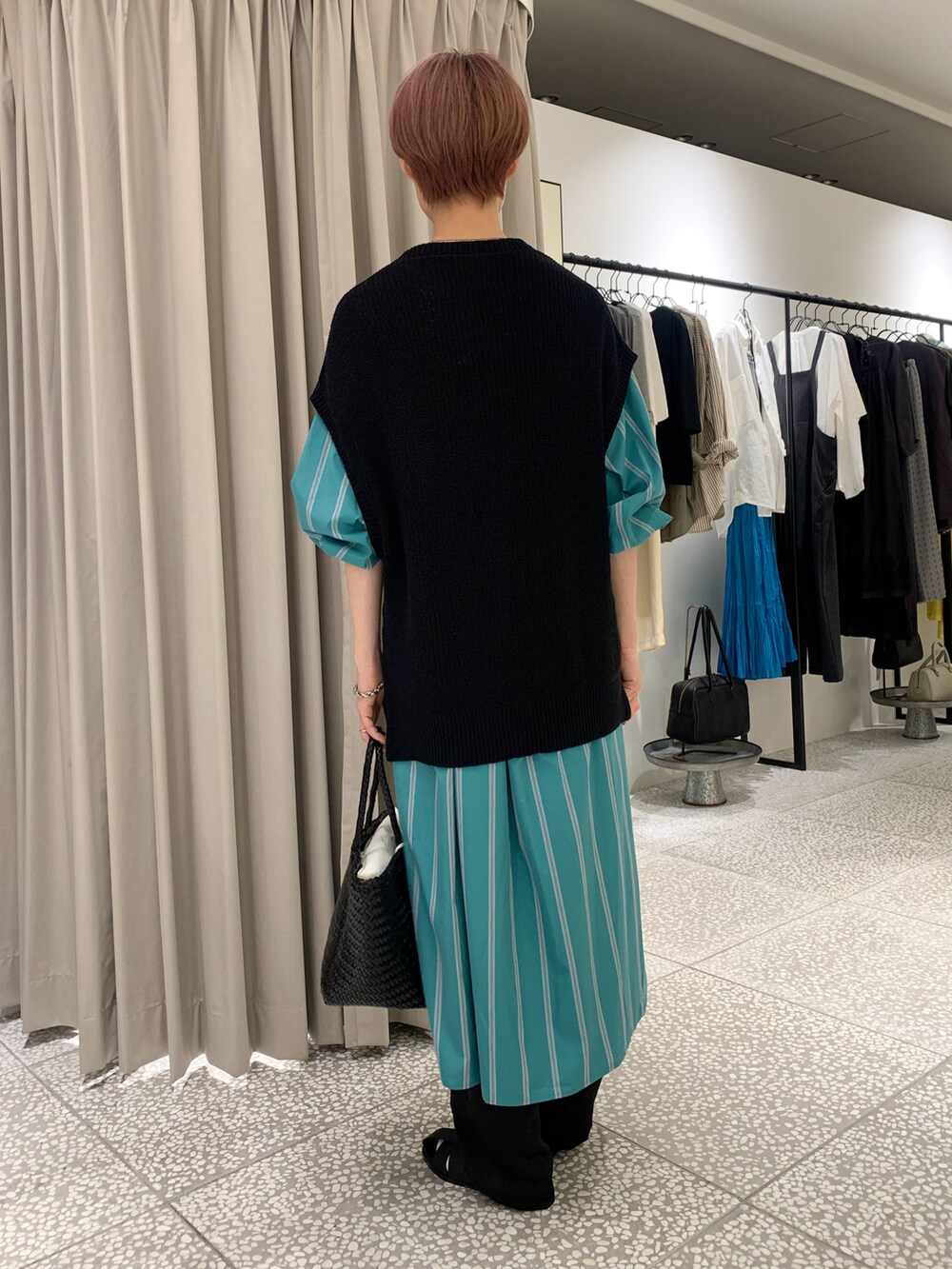 ブラック系のニット/セーター、グリーン系のワンピース、ブラック系のその他パンツを着用したレディースの秋コーディネートの3枚目の写真