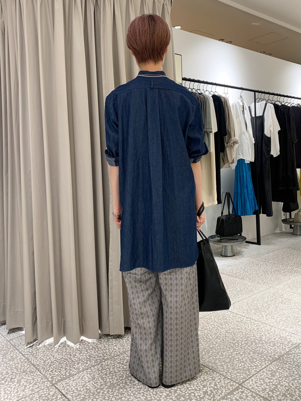 ブルー系のシャツ/ブラウス、ブラック系のトートバッグ、ベージュ系のその他パンツを着用したレディースの秋コーディネートの5枚目の写真