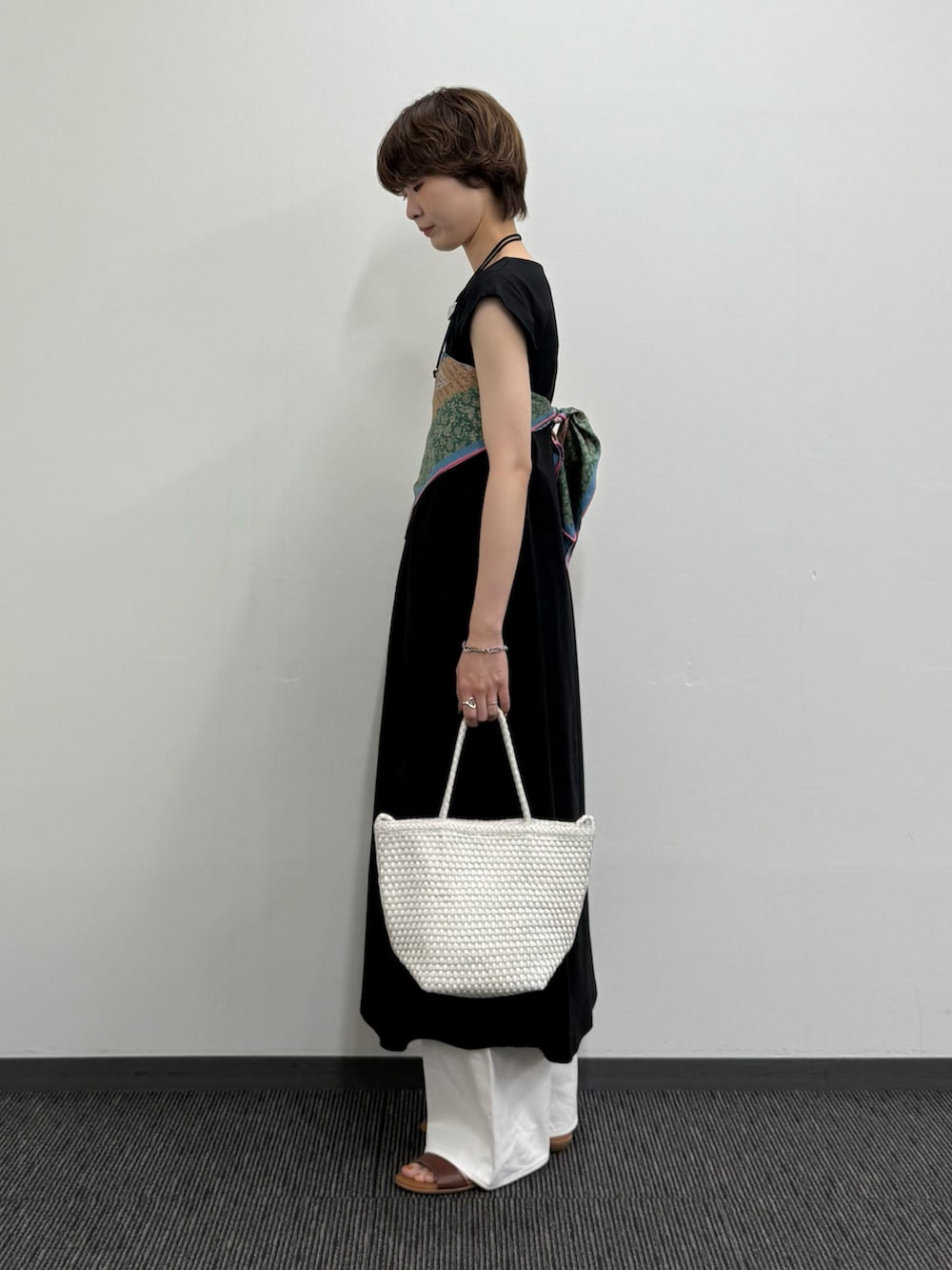 ブラック系のワンピース、ホワイト系のトートバッグ、ブラウン系のサンダルを着用したレディースの夏コーディネートの2枚目の写真