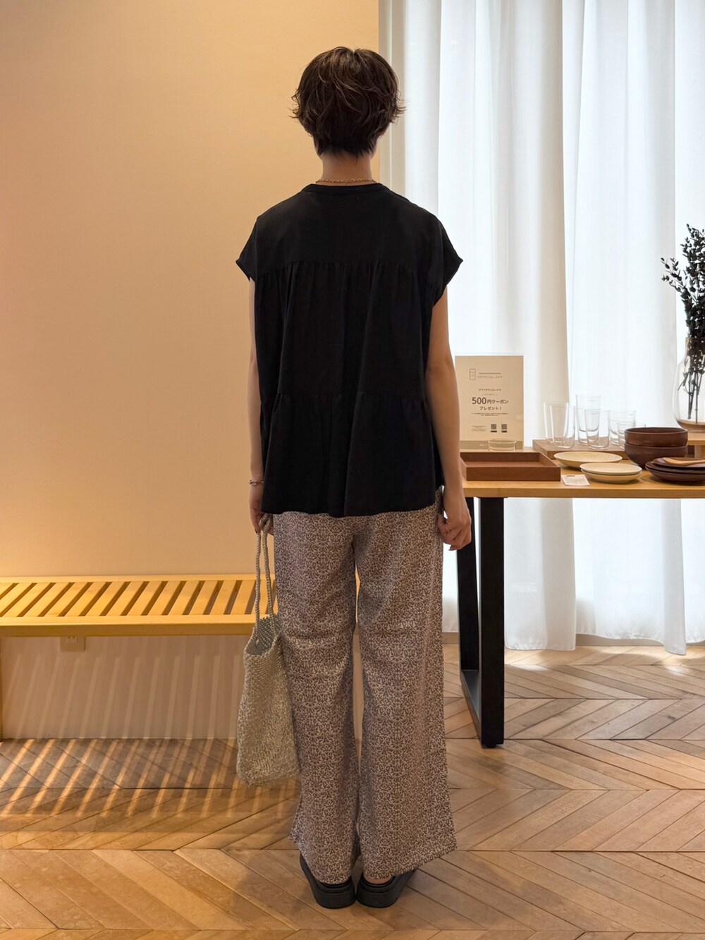 ブラック系のシャツ/ブラウス、ブラック系のその他パンツ、ゴールド系のかごバッグを着用したレディースの夏コーディネートの3枚目の写真