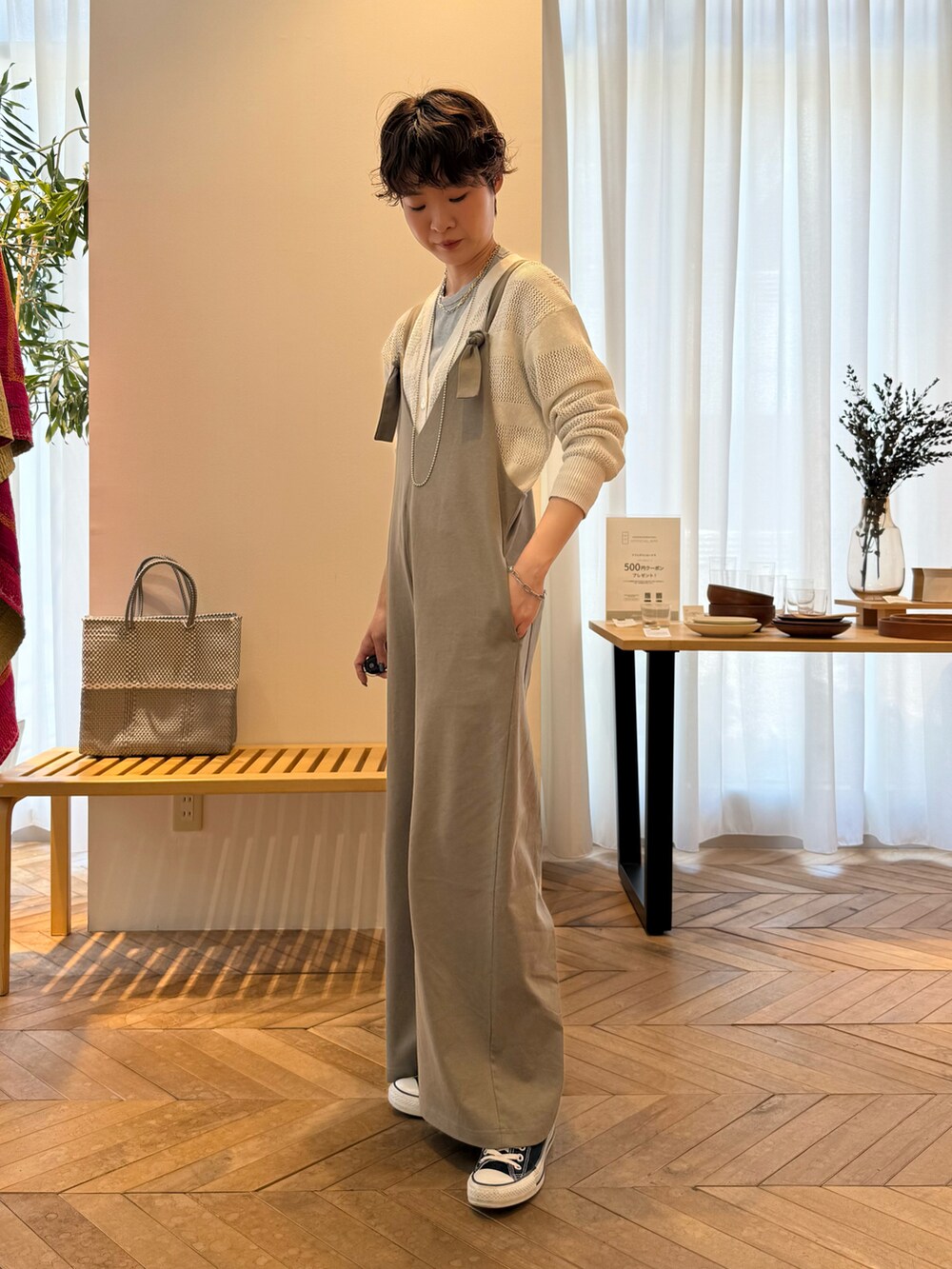 ホワイト系のカーディガン/ボレロ、グリーン系のサロペット/オーバーオール、シルバー系のかごバッグを着用したレディースの夏コーディネートの2枚目の写真