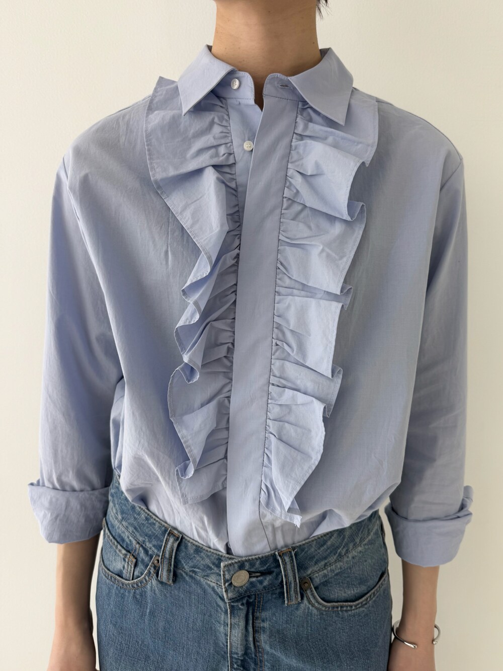 ブルー系のシャツ/ブラウス、ブルー系のデニムパンツ、ブラック系のかごバッグを着用したレディースの春コーディネートの5枚目の写真